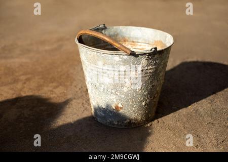 Secchio vecchio all'esterno. Oggetto arrugginito. Metallo rovinato. Foto Stock