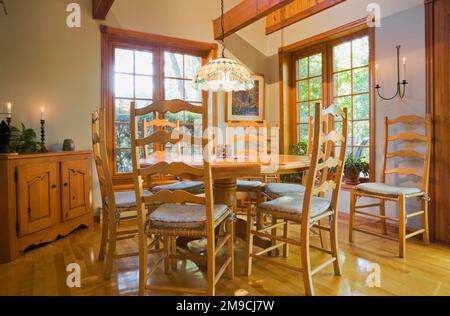 Antico tavolo rotondo per la colazione in legno con sedie a schienale alto nella sala cucina all'interno di una casa in legno in stile canadese. Foto Stock