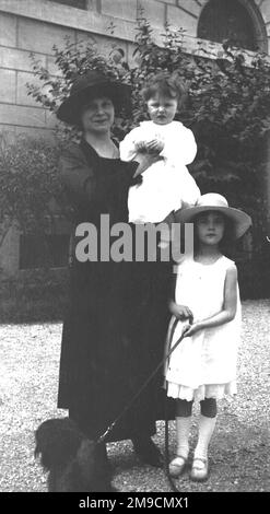 Due bambini in bianco e una donna in nero Foto Stock