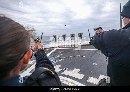 MARE DELLE FILIPPINE (16 maggio 2022) firma Megan Reardon, da Columbia, Carolina del Sud, e Ensign Benjamin Freund, da Old Westbury, New York, spara M9 pistole sul ponte di volo del cacciatorpediniere missilistico guidato di classe Arleigh Burke USS Benfold (DDG 65) durante un tiro di familiarizzazione con le armi. Benfold viene assegnato al Comandante, Task Force (CTF) 71/Destroyer Squadron (DESRON) 15, il più grande DESRON della Marina e la principale forza di superficie della flotta statunitense 7th. Foto Stock