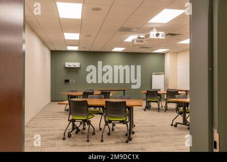 Interno di un ufficio di formazione, riunione, sala conferenze con scrivanie, sedie e lavagna bianca. Nessuno incluso nell'immagine. Foto Stock