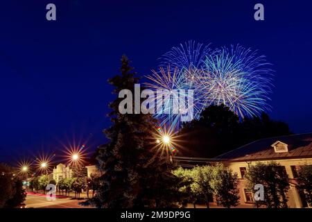 Lampi multicolore di fuochi d'artificio sulla città nella notte di festa Foto Stock