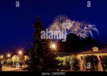 Lampi multicolore di fuochi d'artificio sulla città nella notte di festa Foto Stock