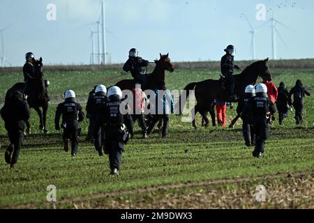 Erkelenz, Germania. 17th Jan, 2023. La polizia montata cerca di fermare gli attivisti e gli oppositori del carbone che cercano di arrivare a Lützerath. Gli attivisti e gli oppositori del carbone continuano le loro proteste martedì in diverse località della Renania settentrionale-Vestfalia. Credit: Federico Gambarini/dpa/Alamy Live News Foto Stock