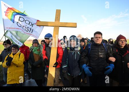 Erkelenz, Germania. 17th Jan, 2023. Gli attivisti e gli oppositori del carbone trasportano una grande croce da una veglia in una processione dimostrativa. Gli attivisti e gli oppositori del carbone continuano le loro proteste martedì in diverse località della Renania settentrionale-Vestfalia. Credit: Federico Gambarini/dpa/Alamy Live News Foto Stock