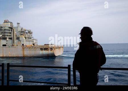 220519-N-CM110-1003 OCEANO PACIFICO (19 maggio 2022) – Un marinaio guarda come carrier anfibio d'assalto USS Tripoli (LHA 7) si avvicina alla nave secca da carico/munizioni USNS Amelia Earhart (T-AKE 6), 19 maggio 2022. Tripoli sta conducendo operazioni di routine nella U.S. 7th Fleet. Foto Stock