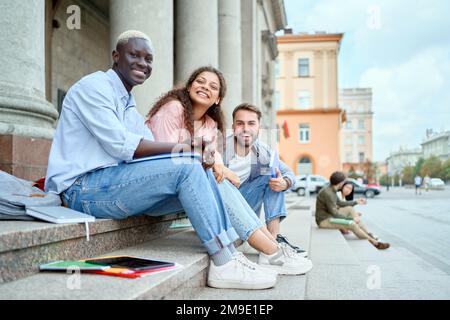 allegra coppia di studenti seduti sui gradini . vista laterale. Foto Stock