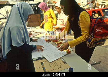 Le donne stanno preparando un concorso di colorazione per bambini nella zona di Gegerkalong, centro delle attività di Daarut Tauhiid, un'istituzione islamica fondata dal famoso predicatore islamico indonesiano, KH Abdullah Gymnastiar, situato a Bandung, Giava Occidentale, Indonesia. Gymnastiar (popolarmente noto come AA Gym), Daarut Tauhiid, e il loro ramo di gestione Manajemen Qolbu (mq), sono riusciti a intensificare il turismo religioso e le attività economiche nella zona di Gegerkalong a Bandung City. Foto Stock