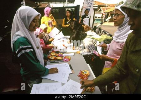 Le donne stanno preparando un concorso di colorazione per bambini nella zona di Gegerkalong, centro delle attività di Daarut Tauhiid, un'istituzione islamica fondata dal famoso predicatore islamico indonesiano, KH Abdullah Gymnastiar, situato a Bandung, Giava Occidentale, Indonesia. Gymnastiar (popolarmente noto come AA Gym), Daarut Tauhiid, e il loro ramo di gestione Manajemen Qolbu (mq), sono riusciti a intensificare il turismo religioso e le attività economiche nella zona di Gegerkalong a Bandung City. Foto Stock