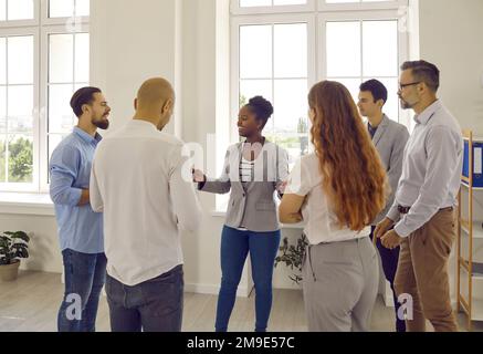Positivo team di lavoro diversificato in ufficio divertirsi a chiacchierare, discutere di lavoro e condividere idee. Foto Stock