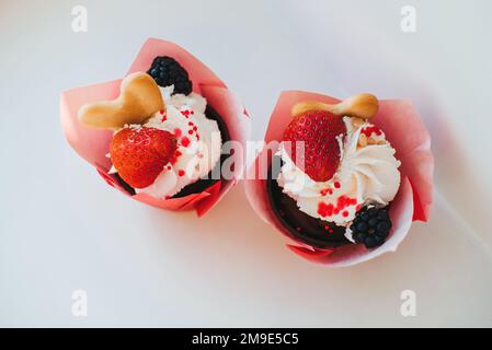 Cupcake con fragole fresche e panna e mora su sfondo bianco Foto Stock