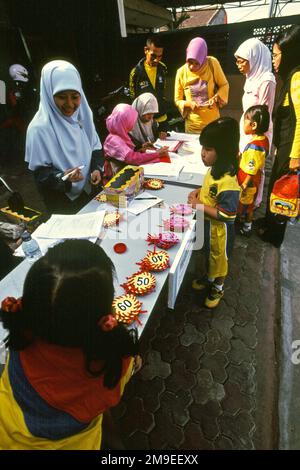 Le donne stanno preparando un concorso di colorazione per bambini nella zona di Gegerkalong, centro delle attività di Daarut Tauhiid, un'istituzione islamica fondata dal famoso predicatore islamico indonesiano, KH Abdullah Gymnastiar, situato a Bandung, Giava Occidentale, Indonesia. Gymnastiar (popolarmente noto come AA Gym), Daarut Tauhiid, e il loro ramo di gestione Manajemen Qolbu (mq), sono riusciti a intensificare il turismo religioso e le attività economiche nella zona di Gegerkalong a Bandung City. Foto Stock