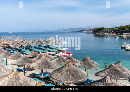 Ksamil, Albania - 11 settembre 2021: Ombrelloni in fila sulla spiaggia di Poda a Ksamil, Albania. Concetto di vacanza sfondo. Foto Stock