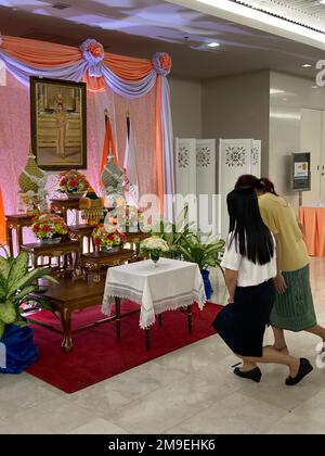 Bangkok, Thailandia. 18th Jan, 2023. Due donne curtsy di fronte all'altare per la principessa Bajrakitiyabha al King Chulalongkorn Memorial Hospital di Bangkok. Accanto al suo ritratto c'è la sua bandiera reale arancione. Il 44-year-old era crollato improvvisamente a metà dicembre ed è stato inconscio da allora. (A dpa: 'Fiori d'arancio e preghiere: La Thailandia teme per la sua principessa') Credit: Carola Frentzen/dpa/Alamy Live News Foto Stock