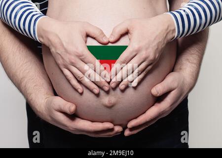 Concetto di famiglia bulgaro. Uomo che abbraccia il ventre e il cuore di donna incinta con bandiera di Bulgaria colori primo piano Foto Stock