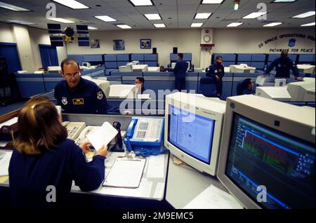 IL capitano dell'aeronautica STATUNITENSE Jennifer Kirby discute le operazioni satellitari con il sergente dell'aeronautica statunitense Jason Boswell nel centro operativo 2nd satellite Operations Squadron - chiamato anche 'Fishbowl' - alla base dell'aeronautica militare di Schriever, Colorado. Il centro è responsabile della costellazione di satelliti del Global Positioning System e garantisce la conformità Y2K. Questa immagine è stata utilizzata nell'articolo di AIRMAN Magazine del novembre 1999 "All in a Good Time". Base: Schriever Air Force base Stato: Colorado (CO) Paese: Stati Uniti d'America (USA) Foto Stock