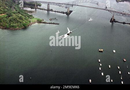 Una Guardia Nazionale dell'aria del Delaware C-130 e due accompagnatori della Guardia Nazionale dell'aria del North Dakota F-16 sono in volo sul canale di Panama. In basso a destra in primo piano ci sono diversi piccoli vasi all'ancora, e sullo sfondo è il Ponte delle Americhe, che si estende sul canale di Panama. Base: Canale di Panama Paese: Panama (PAN) Foto Stock