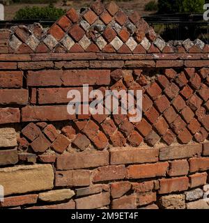 Vista quadrata di mattoni antichi romani decorativi diagonali: Opus reticulatum e Opus mixtum, due tecniche costruttive romane, utilizzate in muratura tra le rovine di Velia, porto greco-romano sulla costa meridionale del Mar Tirreno a Marina di Ascea, Campania. Foto Stock