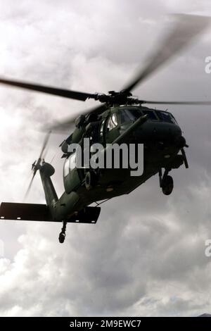 Un colpo da un angolo basso verso l'alto a destra vista frontale medio come HH-60 Pavehawk elicottero pilota US Air Force, 1st Lieutenant un colpo da un angolo basso verso l'alto a destra vista frontale medio come Danny Amegin del 41st Rescue Squadron, Moody Air Force base, Georgia, manovra il suo aereo in posizione durante una simulazione di caduta di parasaveleman (non mostrata), vicino alla base aeronavale Fallon, Nevada. Soggetto operativo/Serie: BASE DI SALVATAGGIO NEL DESERTO: Base aerea navale, Fallon Stato: Nevada (NV) Paese: Stati Uniti d'America (USA) Foto Stock