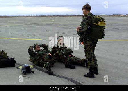 Vista posteriore sinistra ripresa media, come prima di un esercizio di apertura ad alta altitudine e bassa, il sergente dell'aeronautica statunitense Tim Hanks (in piedi), istruirà due membri del 41st Rescue Squadron, Moody Air Force base, Georgia preparare il paracadute prima di salire a bordo di una HC-130 (non mostrata) durante l'esercizio Desert Rescue VII, Presso la base aeronavale di Fallon, Nevada. I membri del 41st Rescue Squadron partecipano a un'esercitazione di salvataggio multiservizio per prepararsi a quando si può verificare una situazione reale. Soggetto operativo/Serie: DESERT RESCUE base: Naval Air Station, Fallon Stato: Nevada (NV) Paese: United Foto Stock