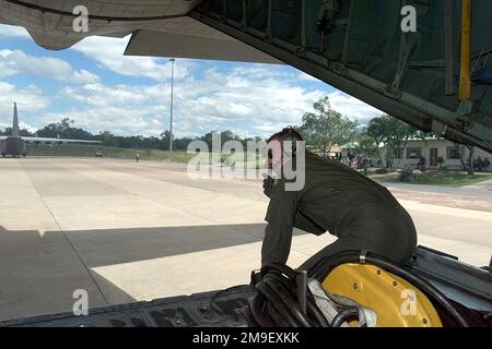 Interno, vista posteriore lato sinistro, scatto medio, come il sergente di USAF Brian Smart, un caricatore C-130 con lo squadrone di sollevamento di 37th di Airlift alla base aerea di Ramstein, Germania, dirige il pilota mentre fa arretrare l'aeromobile dal suo posto di parcheggio alla base dell'aeronautica di Hoedspruit, in Sudafrica. Il 37th Airlift Squadron è dispiegato in Sudafrica per sostenere l'operazione Atlas Response che fornisce aiuti umanitari alle vittime delle inondazioni (non mostrate) del Mozambico meridionale. Subject Operation/Series: ATLAS RESPONSE base: Hoedspruit Air Force base Paese: Sudafrica (ZAF) Foto Stock