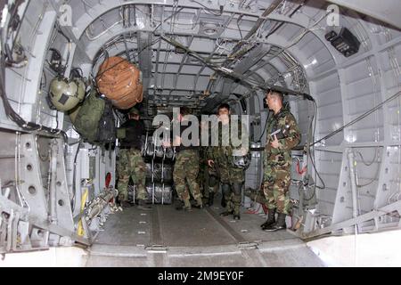 Direttamente sul colpo medio interno in qualità di membri dell'aviazione militare statunitense del 86th Air Mobility Squadron, Ramstein Air base, Germania, E il 21st Special Operations Squadron, Royal Air Force, Mildenhall, Regno Unito, carica un elicottero MH-53 con forniture umanitarie all'aeroporto internazionale di Maputo, Mozambico, Africa, 17 marzo 2000. Essi e i loro equipaggi e equipaggi sono schierati qui a sostegno dell'operazione Atlas Response, un'operazione di aiuto umanitario per aiutare la popolazione del Mozambico, dopo gravi inondazioni (alluvioni e vittime non mostrate) che hanno spostato oltre un milione di persone dalle loro case. Foto Stock