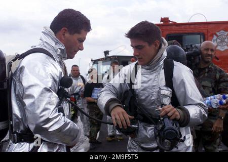 Il generale del Brigadier dell'aeronautica STATUNITENSE Daniel J. Darnell (a sinistra), 31st Comandante dell'ala del combattente, è assistito DA DAVID Brooks di prima classe di AIRMAN, 31st Squadron dell'ingegnere civile, base aerea di Aviano, Italia. Il generale Darnell e A1C Brooks avevano appena completato l'addestramento antincendio degli aerei. Base: Aviano Air base Stato: Pordenone Nazione: Italia (ITA) Foto Stock