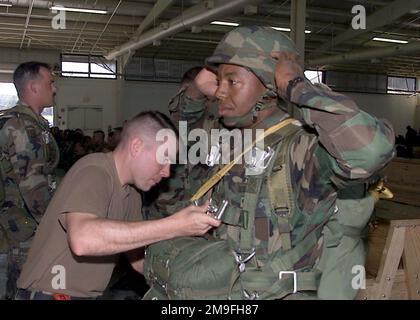 Il capitano dell'esercito DEGLI STATI UNITI William Black, un rigger con la C Company, 82nd Airborne, fornisce un controllo di sicurezza finale al paracadutista, il sergente dell'esercito degli Stati Uniti Sammie Brown della Headquarter Company, 82nd Airborne. SSGT Brown è una delle 5.000 truppe che verranno inserite nella zona di caduta della Sicilia a Fort Bragg, North Carolina. Sta partecipando a un'esercitazione aerea di assalto denominata GRANDE PACCHETTO. L'esercizio di formazione affina la capacità airdrop di Air Mobility Command e di 82nd Airborne. Aerei della 305th Air Mobility Wing, della base dell'aeronautica militare McGuire, New Jersey, della 62nd Airlift Wing, della base dell'aeronautica militare McChord, W Foto Stock