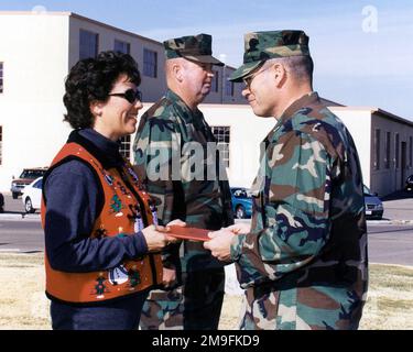 Costa (destra), comandante della base, Marine Corps Logistics base (MCLB), Barstow, California, presenta un certificato di apprezzamento a Sandra Hathaway, moglie del maggiore del sergente della base John D. Hathaway (Center), alla sua cerimonia di ritiro il 22nd dicembre 2000. Base: USMC Logistics base, Barstow Stato: California (CA) Paese: Stati Uniti d'America (USA) Foto Stock