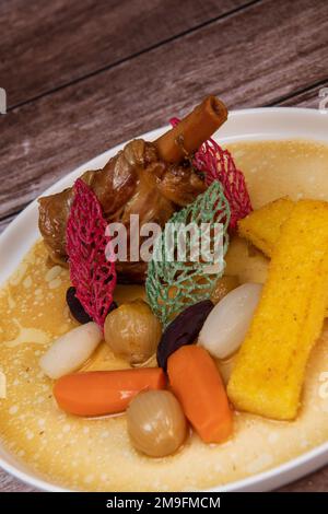 Torta di agnello con polenta fritta, carota, rapa, funghi e salsa Foto Stock