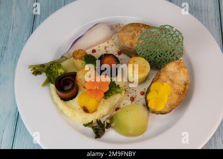 Ricetta di bistecca di merluzzo, purè di patate e la sua farandola di verdure, pastinaca, rapa, broccoli, patate candite Foto Stock