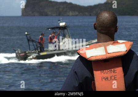 Il Constable Jonas Gideon della polizia Marina di San Luciano tiene d'occhio i suoi compagni ufficiali a bordo di un Cutter della Guardia Costiera, mentre eseguono la pattuglia del porto di Santa Lucia. I membri del 820th Red Horse Squadron, Nellis Air Force base, Nevada, che stanno costruendo la polizia Marina una nuova caserma come parte dell'operazione NUOVI ORIZZONTI, hanno avuto modo di vedere ciò che la Guardia Costiera fa quotidianamente al largo della costa di Santa Lucia. Circa 100 militari, militari e militari hanno schierato a Santa Lucia come parte di New Horizons. L'operazione ha una duplice missione di preparazione e huma Foto Stock