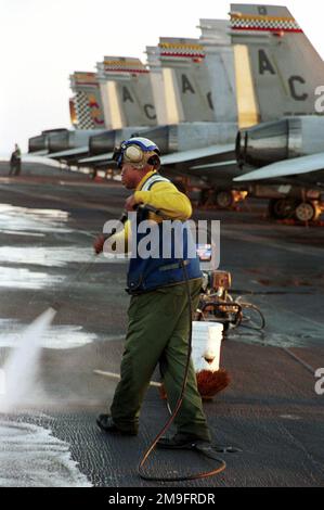 Aviation Boatswain's Mate (Handler), terza Classe, William Watford laverà il ponte di volo in preparazione per le operazioni di volo notturno. TRUMAN è in stazione nel Golfo Arabico a sostegno dell'operazione SOUTHERN WATCH (OSW). L'OSW è la missione che impone la coalizione imposta a sud "no-fly zone” sull'Iraq. Soggetto operativo/Serie: SOUTHERN WATCH base: USS Harry S. Truman (CVN 75) Foto Stock