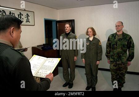 I membri del servizio dell'aviazione MILITARE US Major Eric Steward (a sinistra), Co-Pilot, distaccamento 1, 33rd Rescue Squadron Osan Air base, Repubblica di Corea, Captain Shelly Black (al centro), Pilot, 33rd Rescue Squadron Kadena Air base, Giappone, E Capitano James Thomas (a destra), Dottore, 51st Medical Operations Osan Air base, ROK, ricevere una lettera di apprezzamento dal comandante, ROK Marine Corps Lieutenant Generale Kim Myung Hwan che li onora per il loro salvataggio di una madre in attesa da Ryung Island della costa della Corea. Distaccamento 1 del 33rd Rescue Squadron basato su Osan AB, ROK vola H-60 elicotteri eseguire Foto Stock