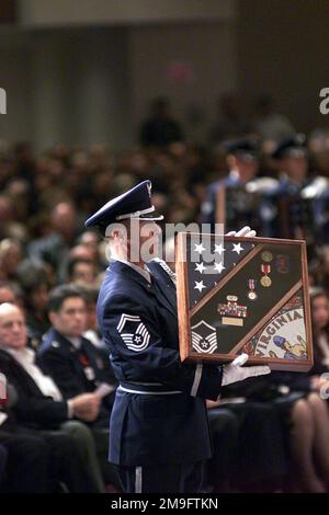 Un membro della Guardia d'onore dell'Aeronautica militare colloca un box ombra nella foto di uno dei 18 membri della Guardia Nazionale dell'Aeronautica della Virginia e di tre membri della Guardia Nazionale dell'Armata della Florida che sono stati uccisi il 3rd marzo in un incidente aereo C-23 Sherpa ad Unadilla, Georgia. Il servizio commemorativo, che ha avuto luogo a Rock Church, Virginia Beach, ha visto la partecipazione del Vice Segretario della Difesa, Paul D. Wolfowitz (non mostrato) e di vari altri dignitari civili e militari e di oltre 4000 membri della comunità. I 18 militari sono stati assegnati al volo a Cavallo Rosso del 203rd alla riserva militare di Stato di Camp Pendleton a Virgi Foto Stock