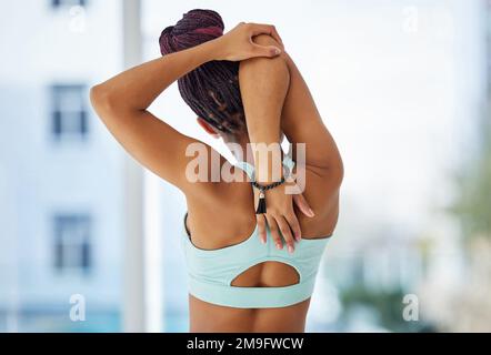 Posso definitivamente ritenere il mio muscolo allungare. una donna irriconoscibile in piedi da sola in uno studio di yoga e stendendo le braccia. Foto Stock