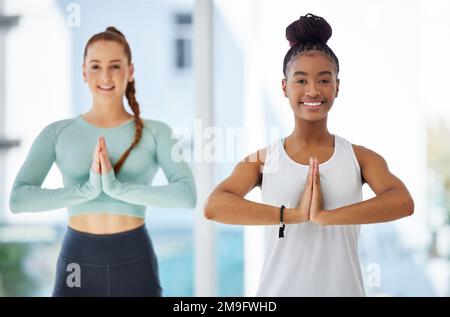 Trovare il nostro zen. due giovani donne in piedi insieme e praticare lo yoga in studio. Foto Stock