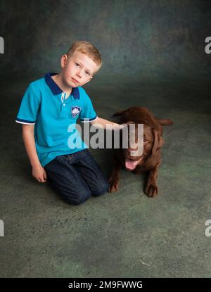 Ritratto di ragazzo con cioccolato Labrador Foto Stock