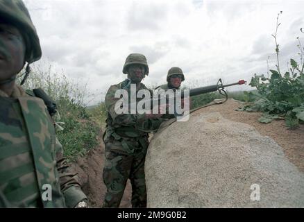 US Marine Corps (USMC) Lance Corporal (LCPL) William Saxton (centro), 3rd battaglione, 4th Marine Regiment, armato di un fucile d'assalto M16A2 5,56mm, con sparo a vuoto, si copre dietro una formazione rocciosa, mentre conduce l'addestramento, durante l'esercizio DEL KERNEL BLITZ 2001. Soggetto operativo/Serie: KERNEL BLITZ 2001 base: Marine Corps base Camp Pendleton Stato: California (CA) Paese: Stati Uniti d'America (USA) Foto Stock