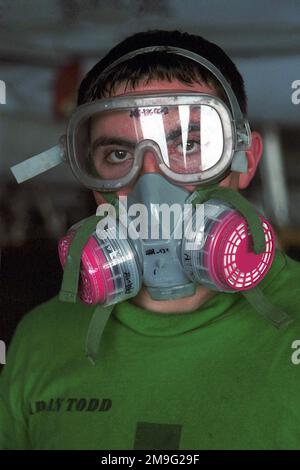 Aviation Machinist's Mate AIRMAN Shaun Todd dona un respiratore mentre si prepara a dipingere l'esterno di un SH-60F Seahawk da Helicopter Antisuman Squadron Seven (HS-7), 'Dusty Dogs', nella baia hangar a bordo della USS Harry S. Truman (CVN 75). TRUMAN è in stazione nel Golfo Arabo a sostegno dell'operazione SOUTHERN WATCH. SOUTHERN WATCH stabilisce una zona di non volo meridionale sull'Iraq e si estende fino ai confini appena a sud di Baghdad, capitale dell'Iraq. Soggetto operativo/Serie: SOUTHERN WATCH base: USS Harry S. Truman (CVN 75) Foto Stock