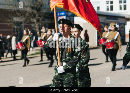 VICHUGA, RUSSIA - 9 MAGGIO 2018: Giovani uomini in uniforme alla parata della vittoria nella seconda guerra mondiale con bandiere Foto Stock