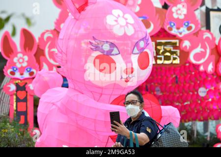 Bangkok. 18th Jan, 2023. Una donna prende un selfie con decorazioni per il prossimo Capodanno lunare di fronte a un centro commerciale a Bangkok, Thailandia, il 18 gennaio 2023. Credit: Rachen Sageamsak/Xinhua/Alamy Live News Foto Stock