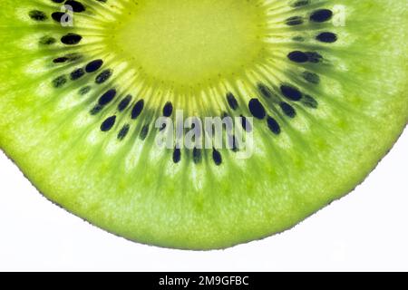 Una fetta solitaria di delizioso Kiwi, fotografata su un fondo bianco Foto Stock