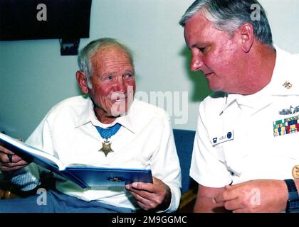 010824-N-4151K-003. [Complete] Scene Caption: US Navy (USN) MASTER CHIEF Quartermaster (QMCM) Kobel (a destra), Command MASTER CHIEF (CMDMC) della Naval Leadership Training Unit (NLTU), parla con il tenente USN (LT) John W. Finn di una voce in un CHIEF Charge Book. I CHIEF PETTY Officer (CPO) appena selezionati trasportano questo libro durante le settimane precedenti la promozione ufficiale raccogliendo parole di saggezza e incoraggiamento da parte di personale più anziano. LT Finn è il più antico vincitore vivente della Medaglia d'onore del Congresso. USN Admiral (ADM) Chester Nimitz ha premiato LT Finn con la Medaglia d'onore per la sua A. Foto Stock