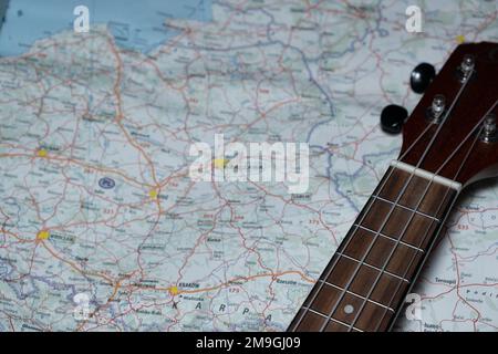 Un colpo ad angolo alto di una chitarra messa sulla mappa della Polonia - concetto di viaggio Foto Stock