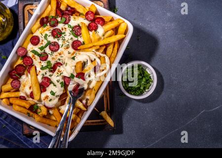 Patatine fritte caricate con la pizza. Pepperoni fatti in casa e formaggio Pizza French Fries. Patatine fritte al forno casseruola di patate con formaggio, peperoni salame e Foto Stock