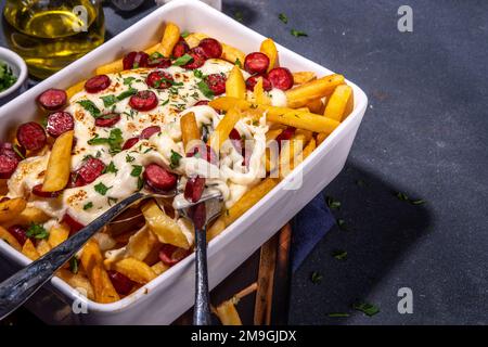 Patatine fritte caricate con la pizza. Pepperoni fatti in casa e formaggio Pizza French Fries. Patatine fritte al forno casseruola di patate con formaggio, peperoni salame e Foto Stock