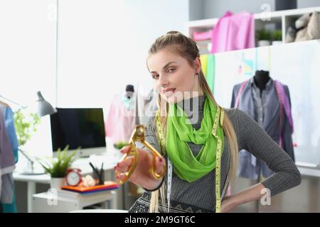 Donna stilista marinaio che tiene le forbici in atelier Foto Stock