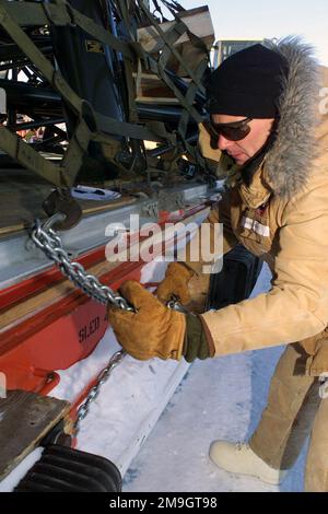 Un lavoratore civile del carico utilizza catene per legare un carico su pallet a una slitta di carico. La slitta trasporta carichi da uno Starlifter C-141C parcheggiato sul ghiaccio alla vicina stazione McMurdo in Antartide, durante l'operazione DEEP FREEZE 2001. Soggetto operativo/Serie: DEEP FREEZE 2001 base: McMurdo Station Paese: Antartide (ATA) Foto Stock