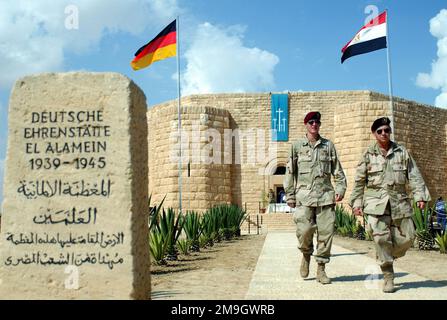011019-F-7203T-003. [Complete] Scene Caption: Due soldati USA camminano vicino all'ingresso del cimitero tedesco a El Alamein, Egitto, durante la Battaglia di El Alamein Memorial Ceremony, tenuta durante l'esercitazione BRIGHT STAR 01/02. La cerimonia commemorò la battaglia tra asse e forze alleate per il controllo dell'Egitto durante la seconda Guerra Mondiale I partecipanti all'esercizio Bright Star hanno preso del tempo per partecipare alla cerimonia commemorativa. BRIGHT STAR 01/02 è un esercizio multinazionale che coinvolge più di 74.000 truppe di 44 paesi che migliora la stabilità regionale e la cooperazione militare-militare tra i nostri punti chiave Foto Stock
